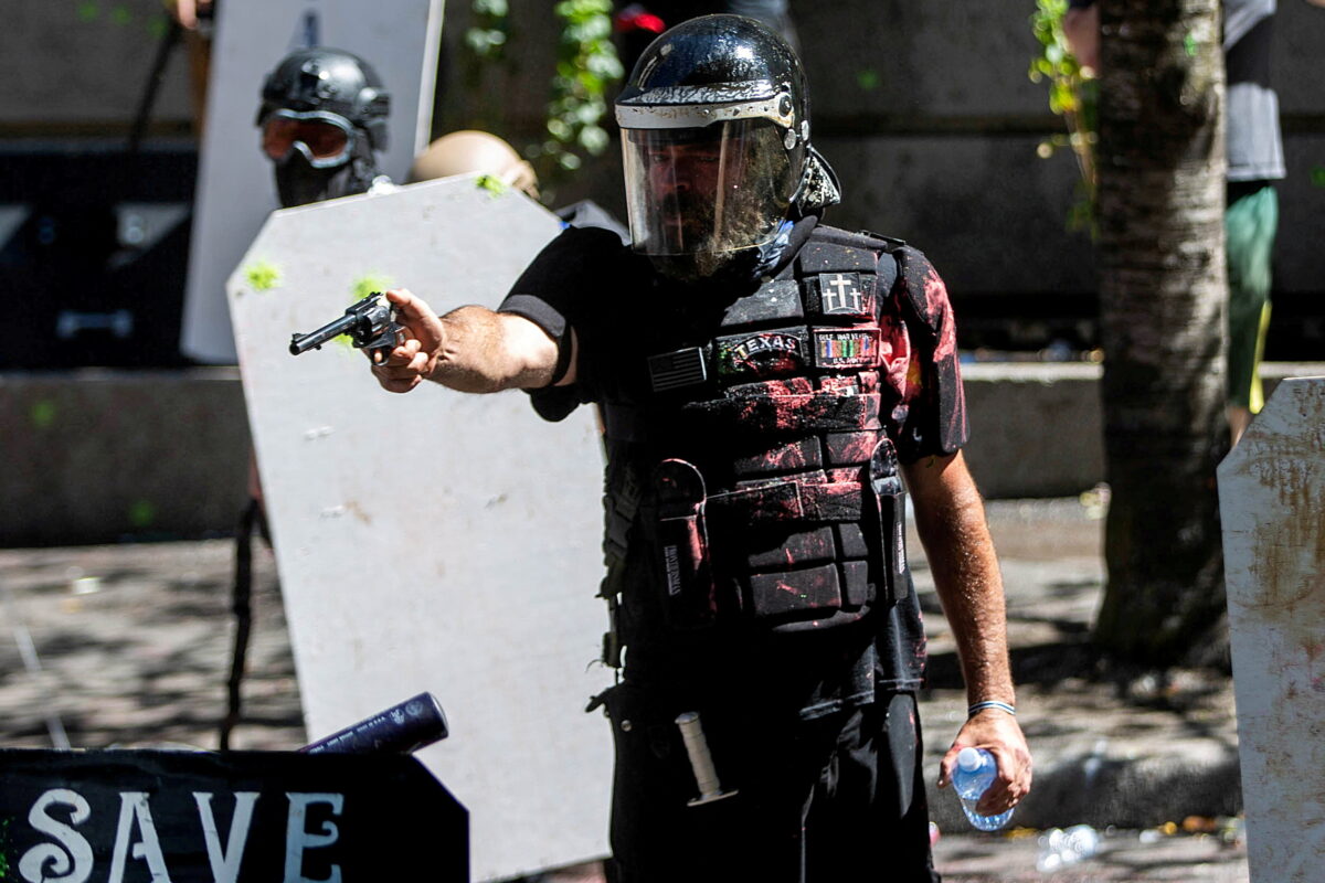 FILE PHOTO: Alan Swinney points a gun during clashes between groups like Proud Boys and Patriot Prayer, and protesters against police brutality and racial injustice in Portland, Oregon, U.S., August 22, 2020. REUTERS/Maranie Staab/File Photo SEARCH "AMERICA IN THE AGE OF TRUMP" FOR THE PHOTOS.